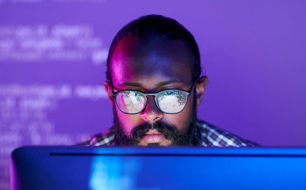 API Developer Developer with glasses working at desktop.