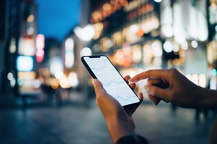 Personne parlant au téléphone, face à une ville la nuit